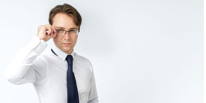 Portrait of a businessman adjusting his glasses. White background. Business and finance concept