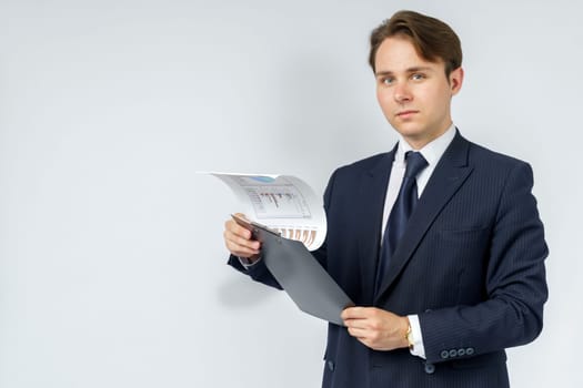 Businessman holds in his hands a tablet with reports. White background. Business and finance concept