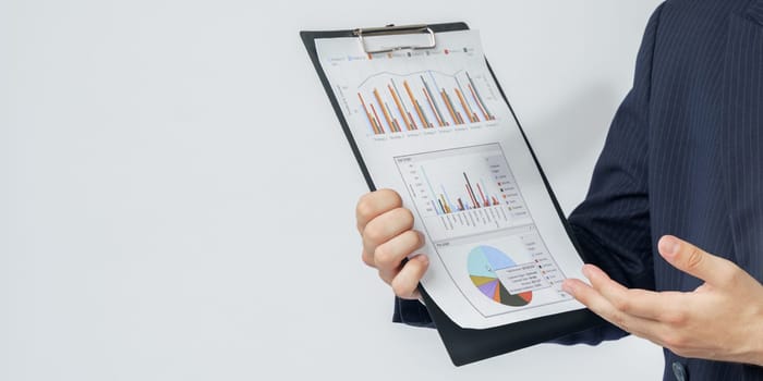 Businessman holds in his hands a tablet with reports. White background. No face visible. Business and finance concept