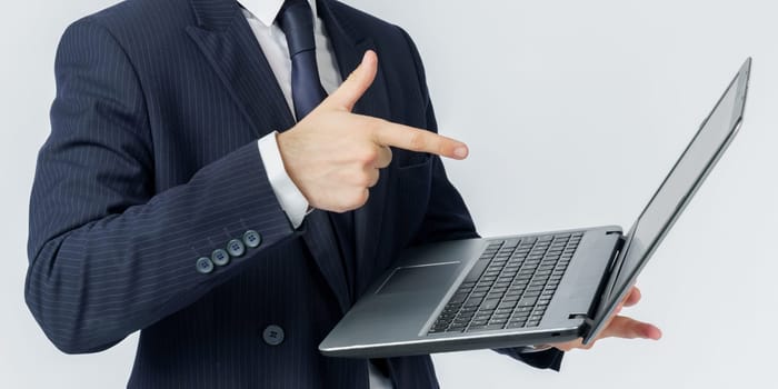 A businessman holds a laptop, the other hand shows the screen. White background. No face visible. Business and finance concept