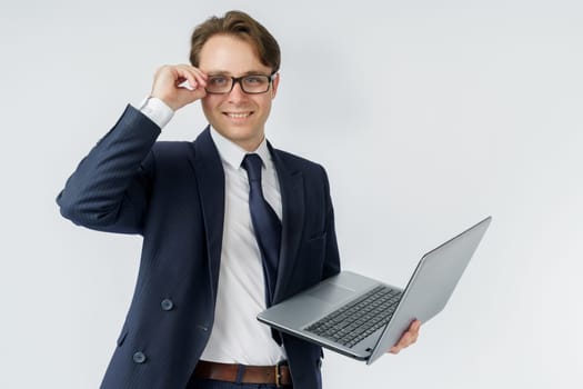 Portrait of a businessman who is holding a laptop and glasses. White background. Business and finance concept