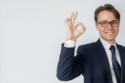 Businessman shows hand gesture OK. White background. Business and finance concept