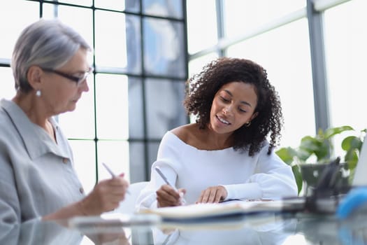 Business women working together on a laptop at a table in the boardroom in the office