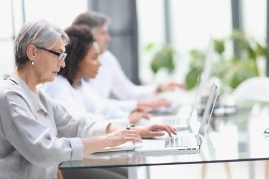 Elderly call center employee at the computer.