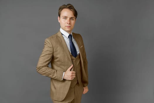 Portrait of a businessman in a suit looking at the camera. Gray background. Business and finance concept