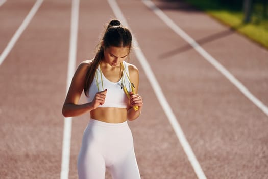 View from the front. Young woman in sportive clothes is exercising outdoors.