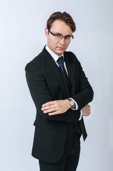 Business and finance concept. Portrait of a businessman in a black suit with glasses. Light background