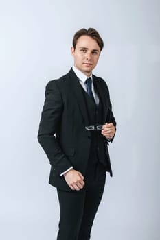 Business and finance concept. A man in a black suit holds glasses in his hands. Light background