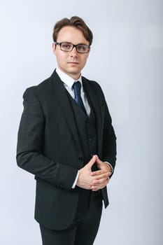Business and finance concept. Portrait of a businessman in a black suit with glasses. Light background
