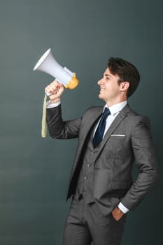 Business and finance concept. Portrait of a businessman who holds a megaphone in his hands. Light background