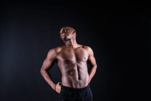 Portrait of athletic african american man topless, black background