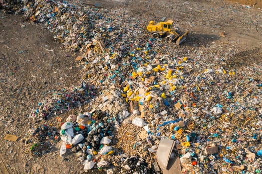 Excavator collects garbage from a landfill for recycling. Ecological catastrophe due to non biodegradable waste and plastic