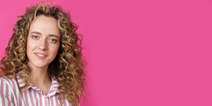 Close-up portrait of a smiling young woman. Banner. Isolated pink background.