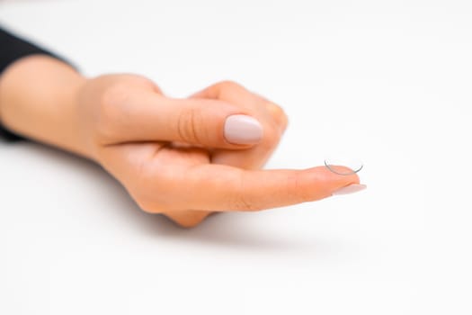 Disposable contact lenses in woman hands on the white background