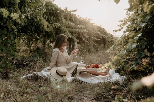 Picnic and wine tasting at sunset in the hills of Italy, Tuscany. Vineyards and open nature in the summer. Romantic dinner, fruit and wine.