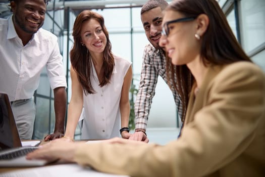 Diverse multinational team having a conversation in a conference room in a creative office.