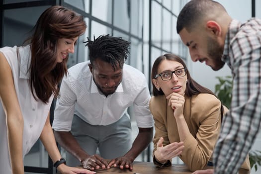 Business team discussing financial charts while standing at the table in the office