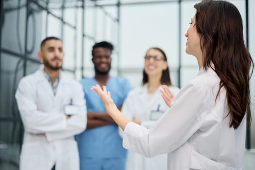 Cheerful doctor smiling happily posing in front of the hospital medical team