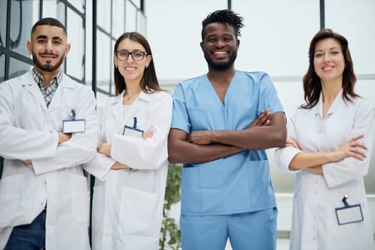 Hospital staff with and clipboard looking at camera in clinic