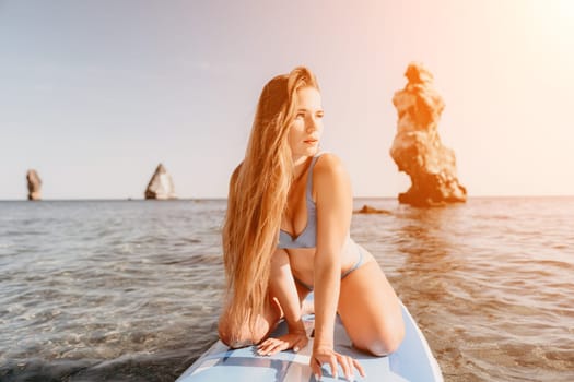 Close up shot of happy young caucasian woman looking at camera and smiling. Cute woman portrait in bikini posing on a volcanic rock high above the sea