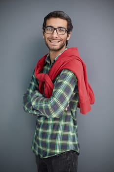 Smiling young unshaven business man posing against gray wall background studio portrait.