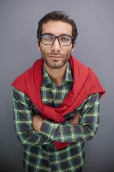 Stylish male portrait of a handsome young guy with a hairstyle and vintage glasses in a fashionable plaid shirt