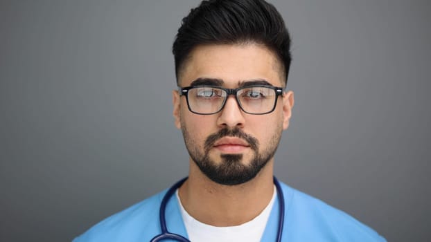 Headshot of male doctor on gray background