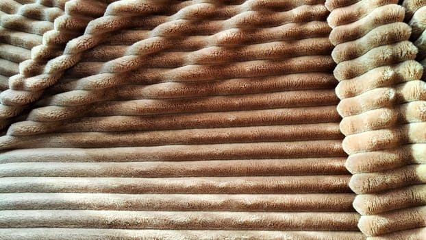 Closeup photo of soft, fluffy sleeping beige blanket or plaid. Crumpled fabric. Abstrack background and texture with frame. Partial focus