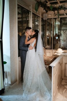 bride and groom inside a cocktail bar in a bright atmosphere with a glass of drink