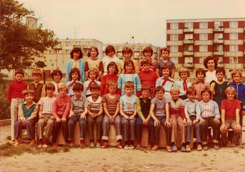 THE CZECHOSLOVAK SOCIALIST REPUBLIC - CIRCA 1980s : Retro photo shows pupils (schoolmates) and their female teacher. Some girls wear young pioneer uniform. Color photography.