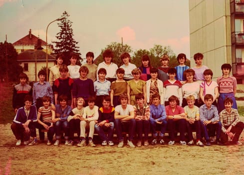 THE CZECHOSLOVAK SOCIALIST REPUBLIC - CIRCA 1980s: Retro photo of group of school pupils (teenagers) with their female teacher. Color photo