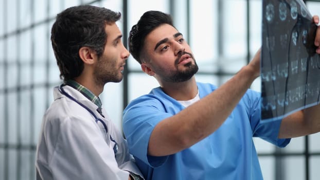 Doctors and an intern examine an X-ray of a patient. MRI scans of brain activity and scientists.