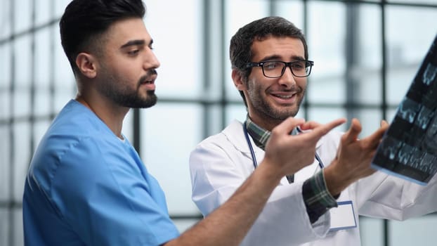 Doctors and an intern examine an X-ray of a patient. MRI scans of brain activity and scientists.