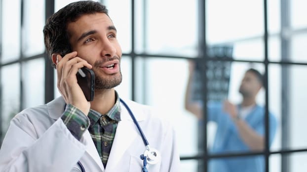 Shot of a male doctor talking on a mobile phone during a hospital