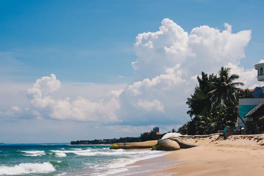 A beach with a boat on it and a cloudy sky in the background.