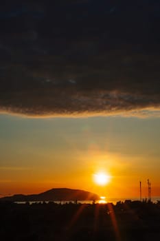 A sunset with a dark cloud in the sky.