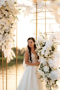 bride against the background of a yellow sunset on a pier near the river