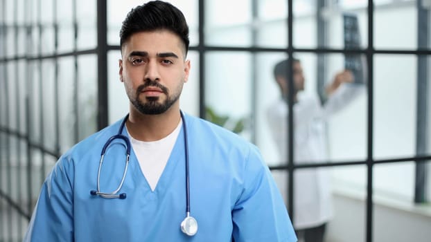 Cheerful mature doctor posing at camera, healthcare and medicine.