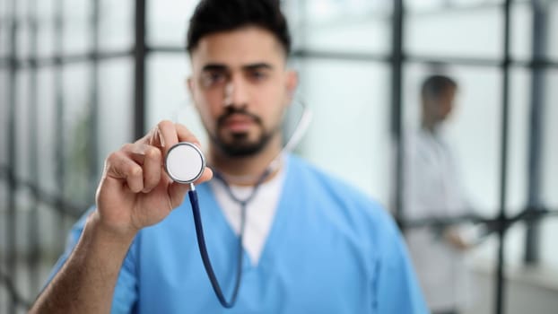 A futuristic doctor shows stethoscope and appear of advanced futuristic medicine symbols in holography.