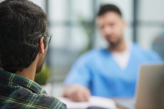 Nurse explaining to a young male patient in an office in a hospital