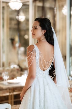 portrait of a bride in a white dress in a bright cafe with mirrors