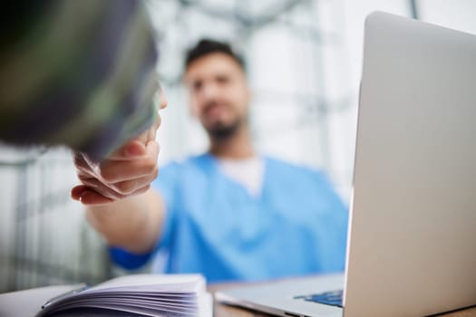 medicine, healthcare and people concept - smiling doctor with clipboard and young man patient meeting at hospital