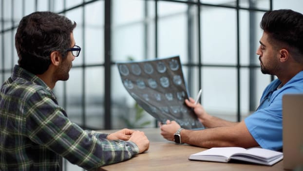 Pensive serious mature adult male physician consult shocked young man