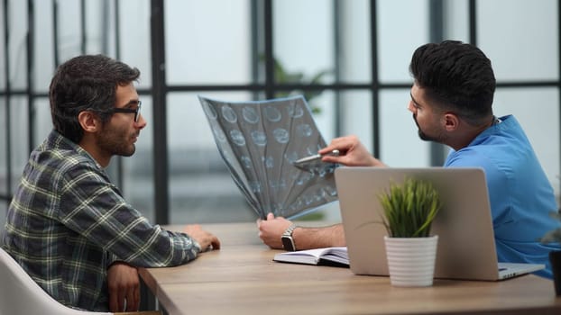 Pensive serious mature adult male physician consult shocked young man