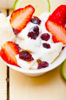 fruit and yogurt salad healthy breakfast over white wood table