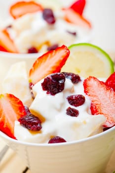 fruit and yogurt salad healthy breakfast over white wood table