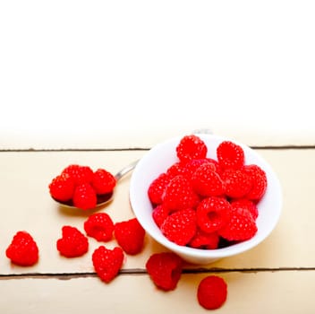bunch of fresh raspberry on a bowl and white wood rustic  table
