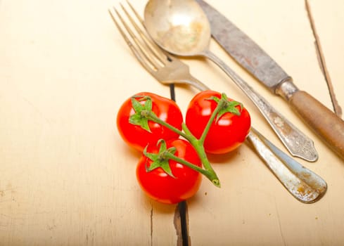 ripe cherry tomatoes cluster over white rustic wood table