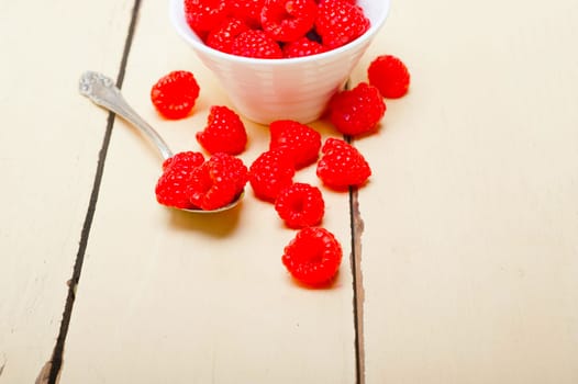 bunch of fresh raspberry on a bowl and white wood rustic  table