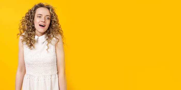 Portrait of a young woman who is surprised. Female portrait. Isolated on yellow background